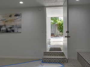 Entryway featuring recessed lighting, a textured ceiling, and tile patterned flooring