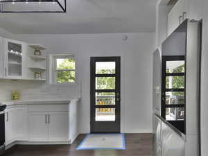 Doorway featuring wood finished floors, a textured ceiling, and healthy amount of natural light