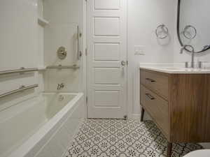 Full bathroom with vanity, light tile patterned floors, and shower / bathtub combination