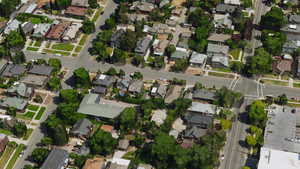 Aerial view of property and surrounding area featuring nearby suburban area