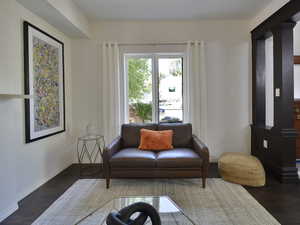 Living area with wood finished floors and decorative columns