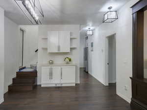 Kitchen with white cabinetry, light countertops, open shelves, a textured ceiling, and dark wood-style flooring
