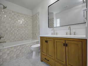 Full bath with tiled shower / bath and double vanity