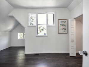 Bonus room featuring lofted ceiling and dark wood-type flooring