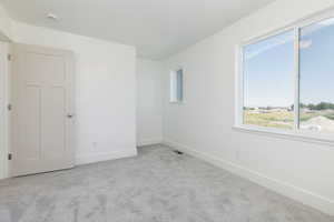 Carpeted spare room with baseboards