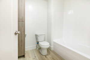 Bathroom featuring light wood-type flooring and tub / shower combination