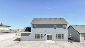Rear view of house with roof with shingles and a patio