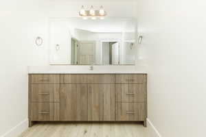 Half bathroom with vanity and light wood-type flooring