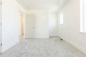 Empty room featuring light colored carpet