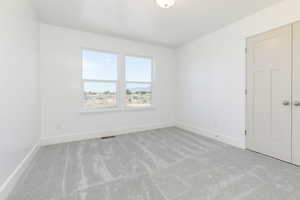 Empty room featuring light colored carpet
