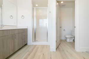 Full bath with vanity, a shower stall, recessed lighting, and light wood-style flooring