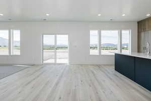 Unfurnished living room with a mountain view, recessed lighting, and light wood finished floors