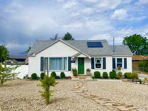 View of front facade with roof mounted solar panels and easy maintence xeroscaping.