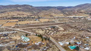 Aerial view of property and surrounding area featuring a mountain backdrop and rural landscape