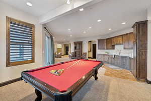 Playroom with arched walkways, light colored carpet, recessed lighting, pool table, and light tile patterned floors