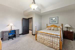 Bedroom featuring light carpet and baseboards