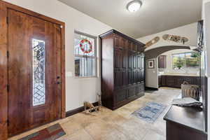 Entryway with arched walkways and light tile patterned floors