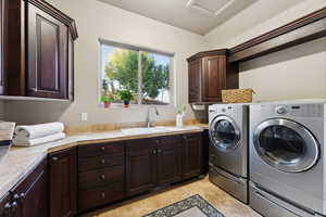 Laundry area with cabinet space, independent washer and dryer, and light tile patterned flooring