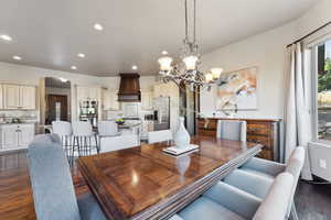 Dining space with dark wood-type flooring, arched walkways, a chandelier, and recessed lighting