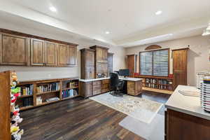 Office space with dark wood-type flooring and recessed lighting