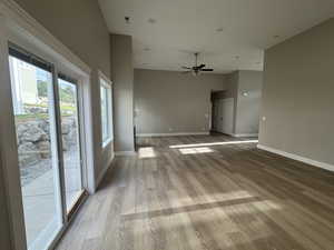 Empty room with light wood-style floors and ceiling fan