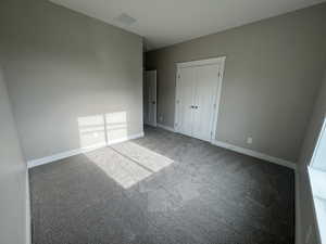 Unfurnished bedroom featuring carpet floors and a closet