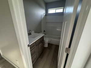 Bathroom with vanity, tub / shower combination, and dark wood finished floors