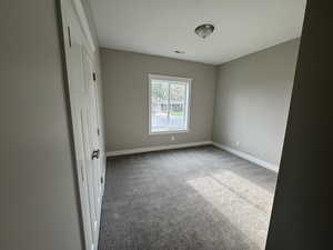 Unfurnished bedroom featuring carpet flooring and baseboards