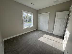 Unfurnished bedroom featuring carpet flooring and a closet