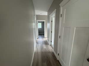 Hallway with baseboards and wood finished floors
