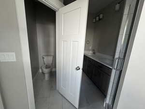 Full bathroom featuring double vanity, light marble finish flooring, and a stall shower