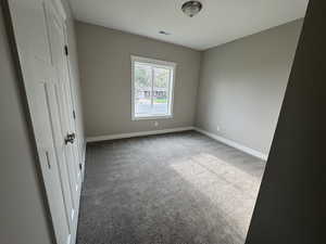 Unfurnished bedroom featuring light colored carpet and baseboards