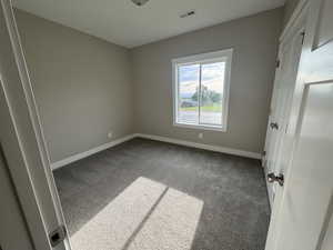 Unfurnished bedroom with carpet floors and baseboards