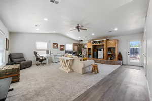 Living area with vaulted ceiling, ceiling fan, light wood-type flooring, a textured ceiling, and recessed lighting