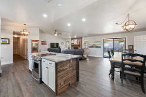 Kitchen featuring decorative light fixtures, a chandelier, a fireplace, lofted ceiling, and open floor plan