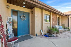 View of exterior entry featuring stucco siding and a patio area