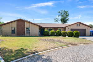 View of front of property with stucco siding, driveway, a tiled roof, and a garage
