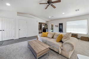 Living room featuring lofted ceiling, a ceiling fan, and recessed lighting