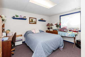 Bedroom with carpet floors and a paneled ceiling