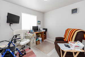 Home office featuring light carpet and baseboards