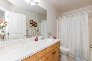 Bathroom with vanity, shower / bathtub combination with curtain, and light tile patterned flooring