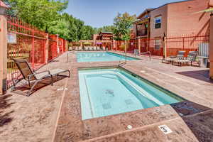 Community pool featuring a hot tub and a patio area