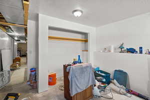 Home office featuring unfinished concrete flooring and a textured ceiling