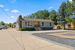 View of front of property featuring driveway and a chimney