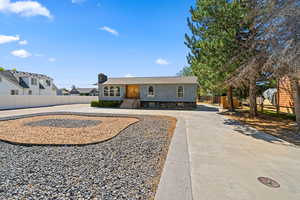 Ranch-style house with a chimney and curved driveway