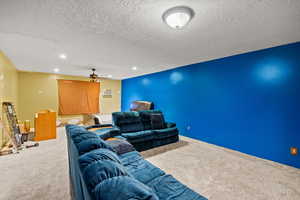 Home theater room with carpet floors, a ceiling fan, a textured ceiling, and recessed lighting