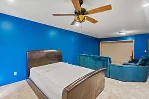 Carpeted bedroom featuring ceiling fan