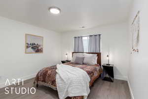 Bedroom with wood finished floors and baseboards