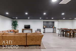 Living area with recessed lighting and light wood-style flooring
