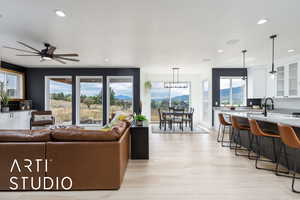 Living area with ceiling fan, a mountain view, recessed lighting, and light wood-style flooring